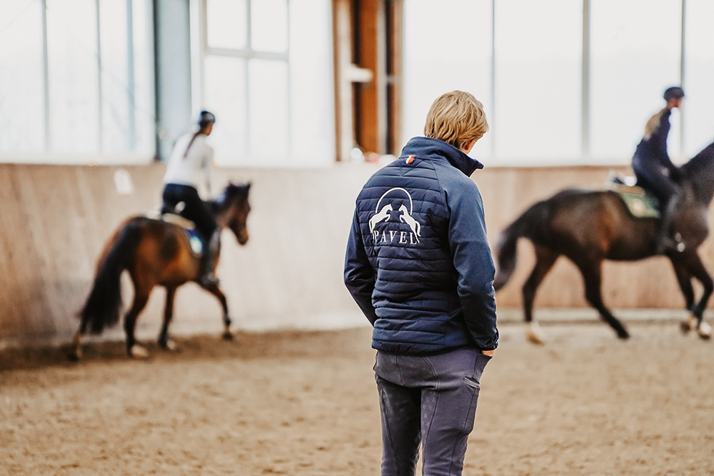 Philipp Pavel beobachtet aufmerksam Schüler beim Reiten in Reithalle