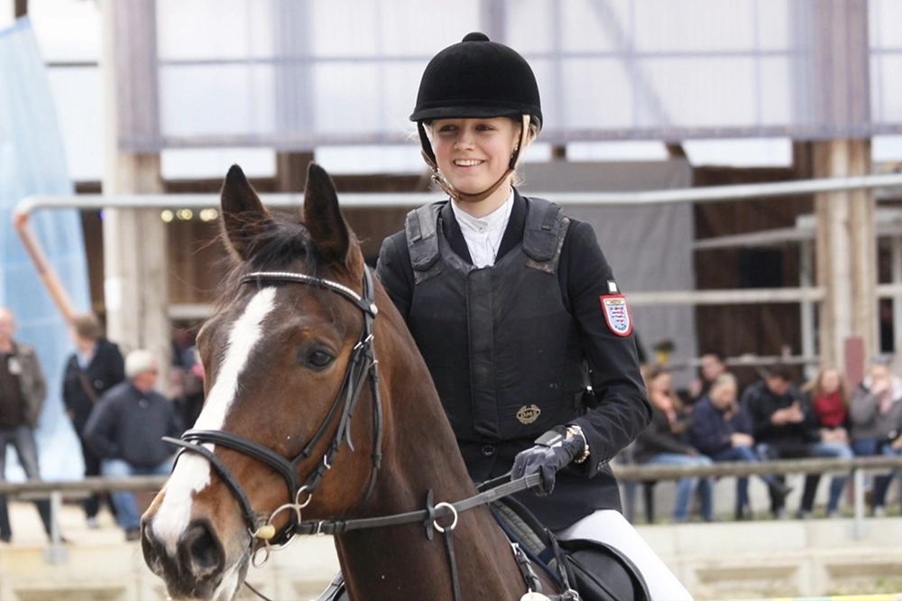 Turnierteilnehmerin auf dunkelbraunem Pferd