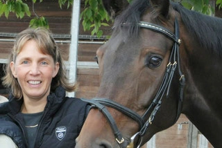 Esther Pavel steht neben dunkelbraunem Pferd